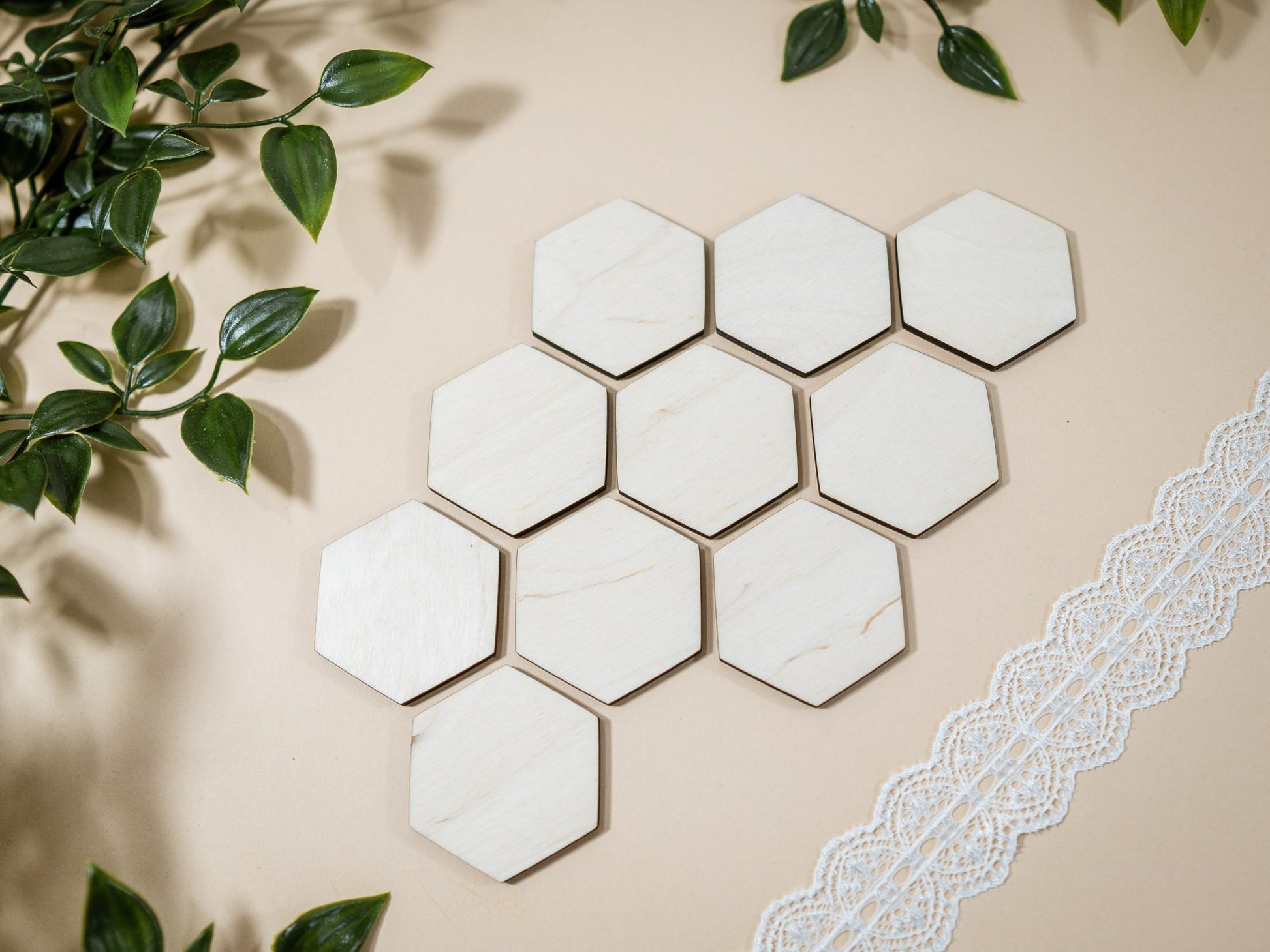 Hexagonal marble tiles on a beige background with green leaves.