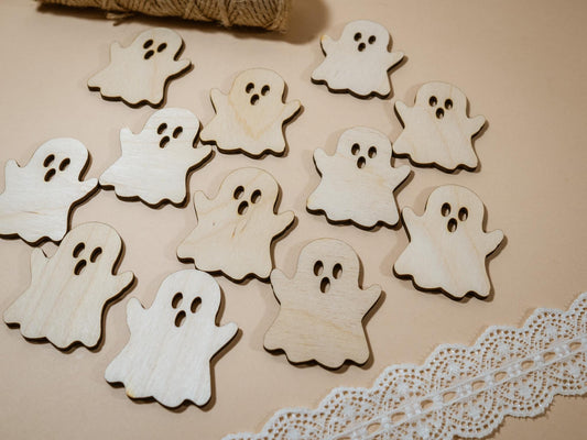 Wooden ghost shapes on a beige surface with twine and lace trim.