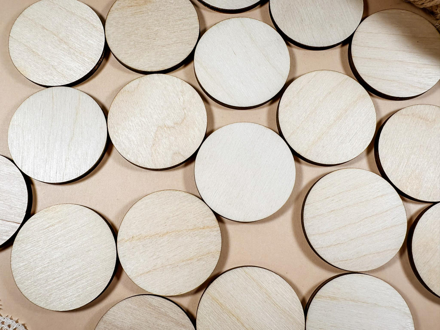 Round wooden coasters on a beige surface with lace and twine.