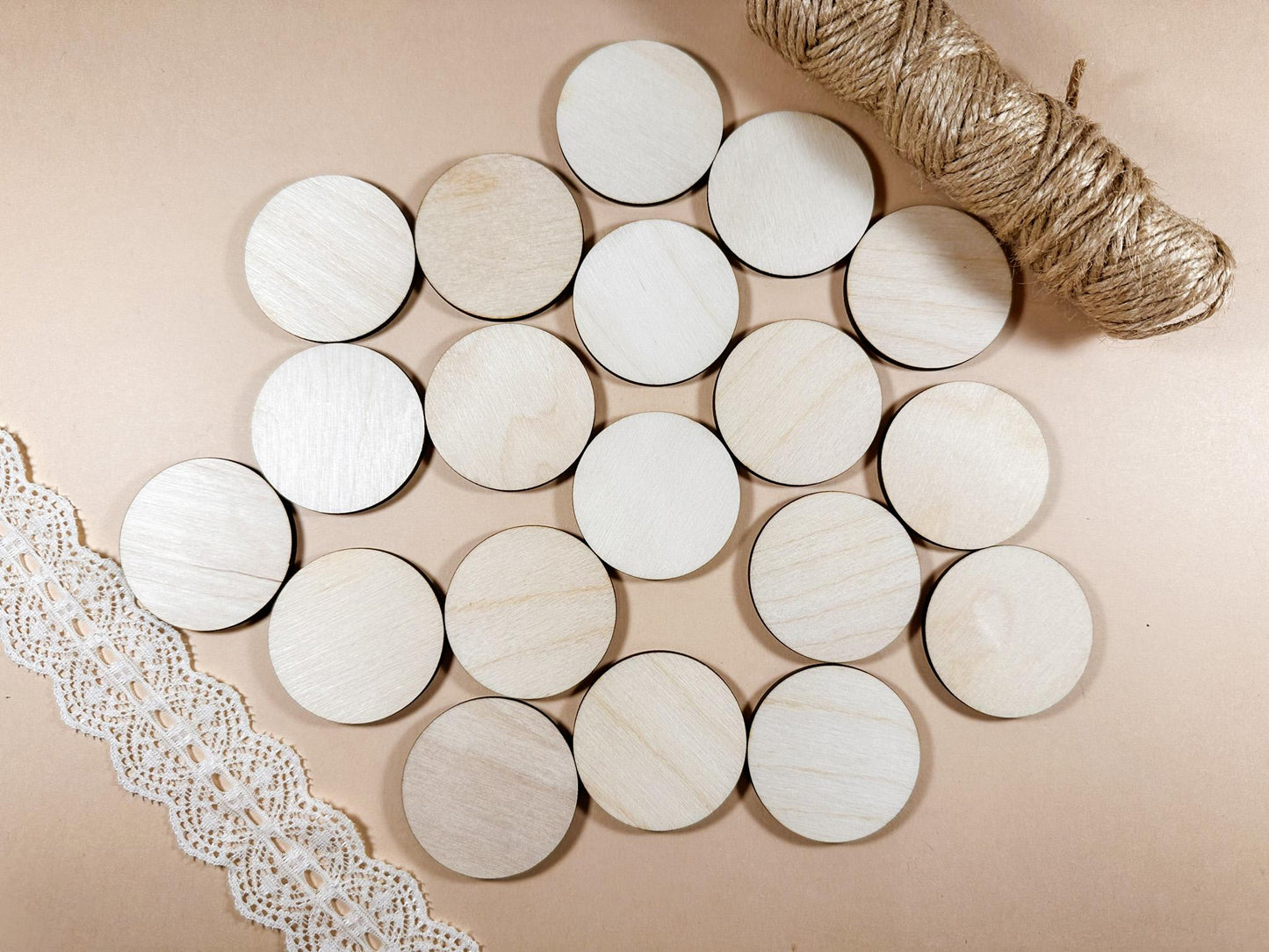 Round wooden coasters on a beige surface with lace and twine.