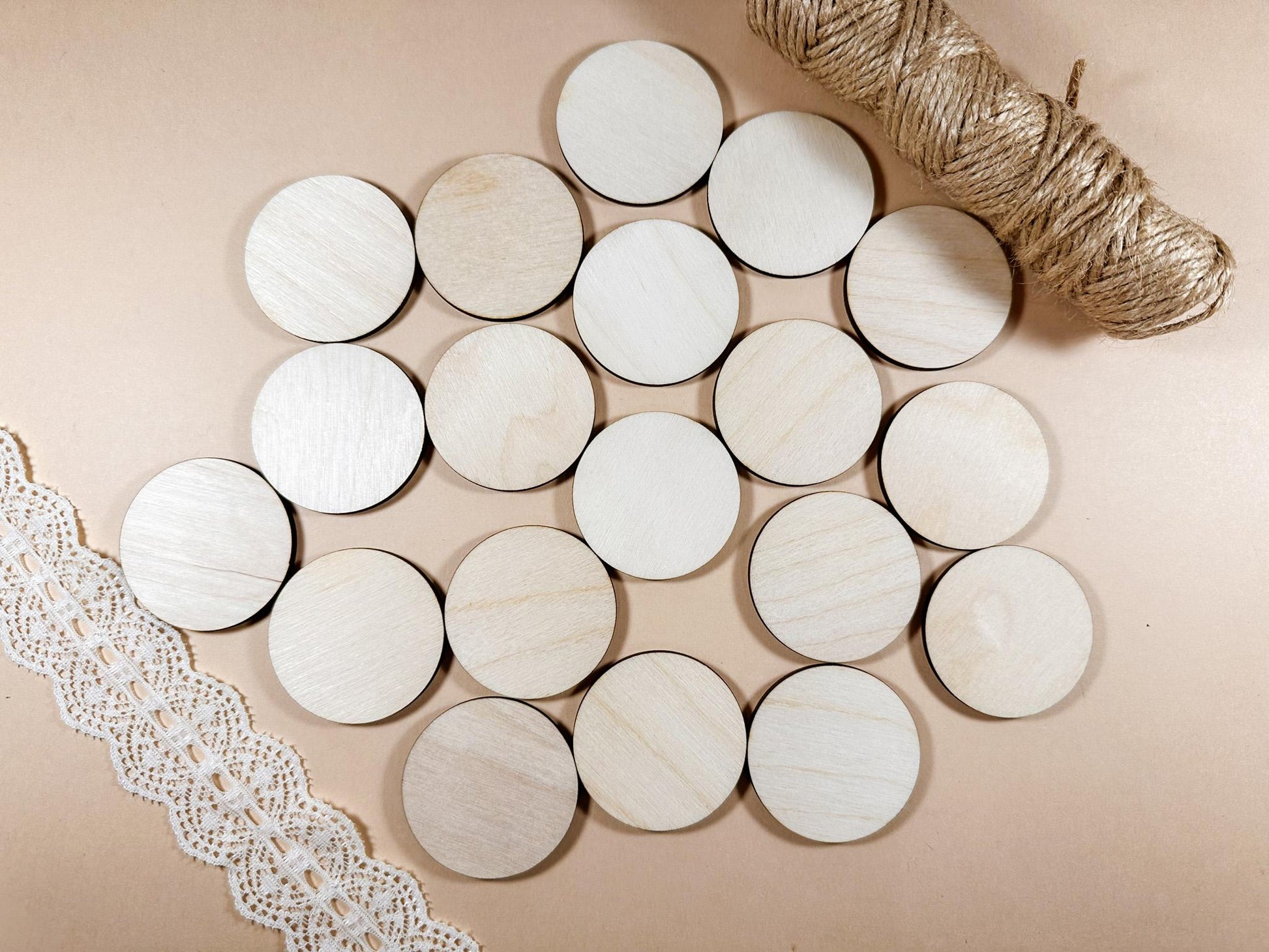 Round wooden coasters on a beige surface with lace and twine.