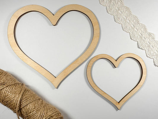 Two wooden heart shapes with twine on a light background