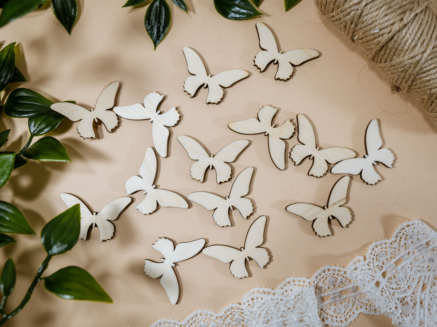 Wooden butterfly decorations on a surface with greenery and twine in the background
