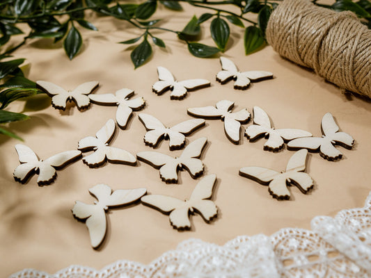 Wooden butterfly decorations on a surface with greenery and twine in the background